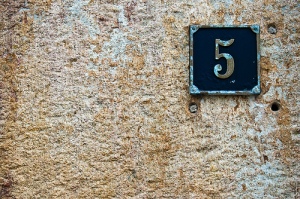 Number 5 address plate on an old stucco building